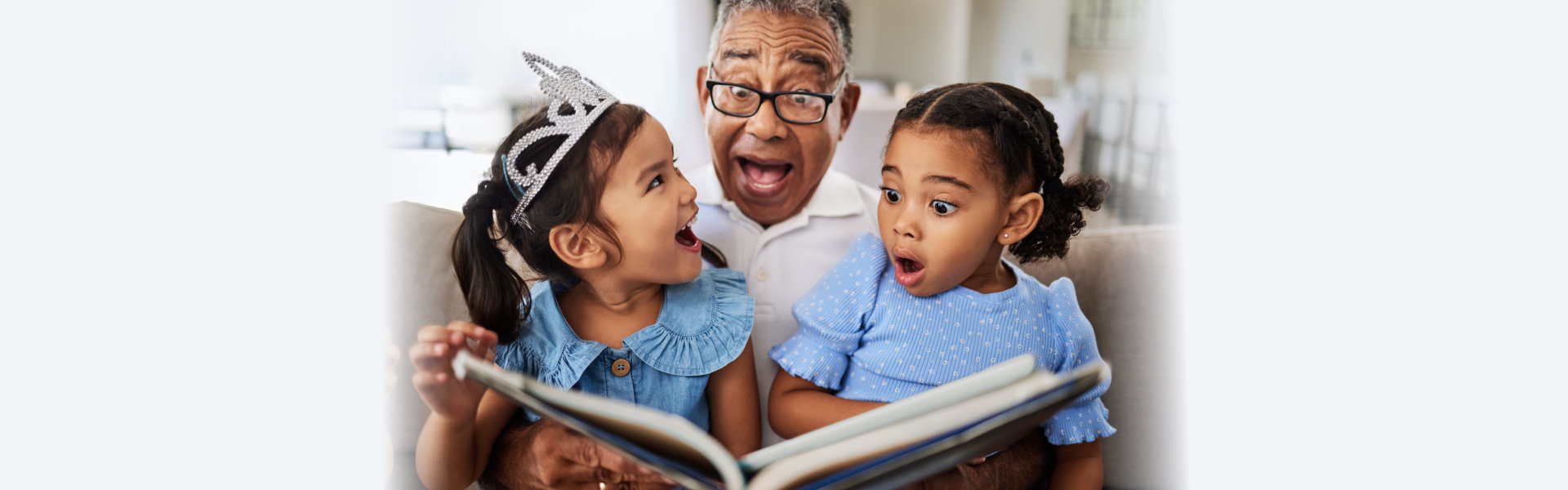 kids smiling while they're grandpa reads them a story